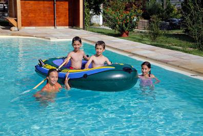 I bambini giocano in piscina col battellino gonfiabile